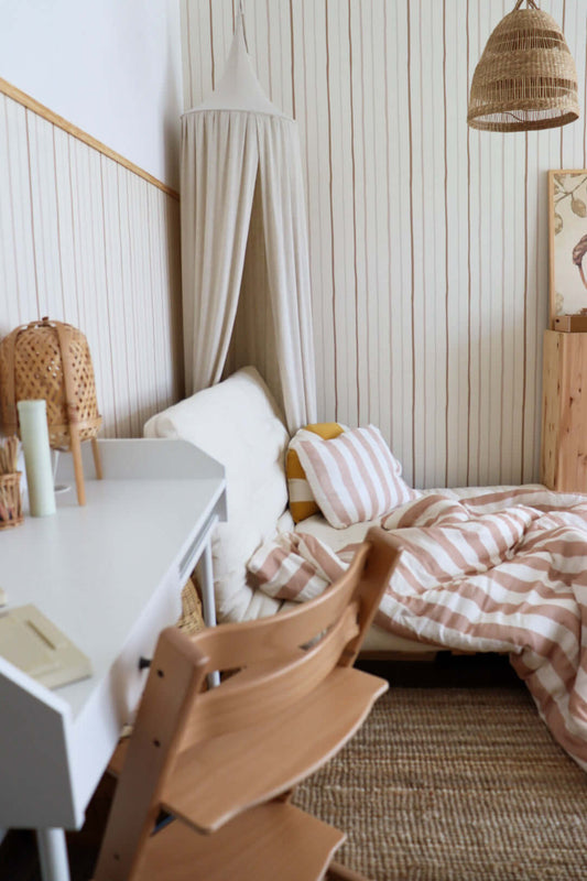 Matuu Neutral Stripes on Cream wallpaper – cozy kids’ room with striped bedding and canopy