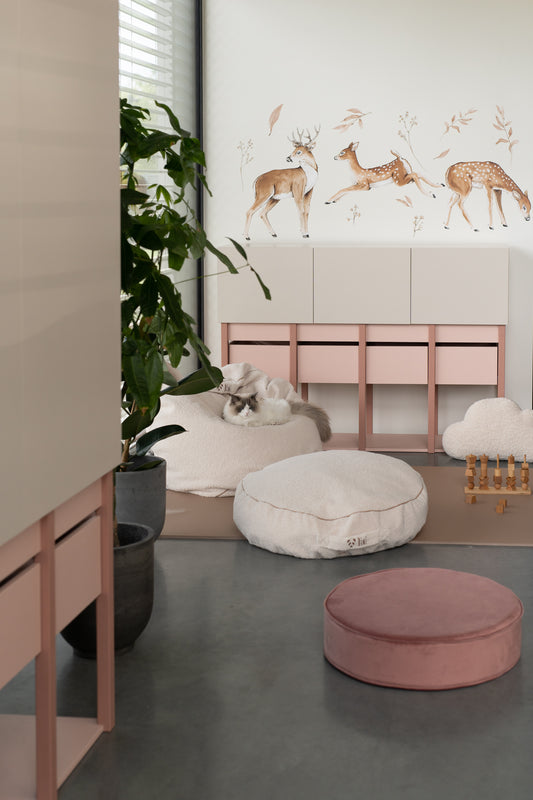Modern nursery room with Matuu deer wall decals, white armchair and soft pink pouf.