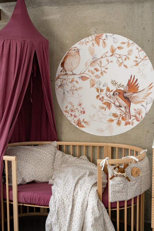 Nursery with round bird decal by Matuu – natural wall art in calming, warm-toned interior.