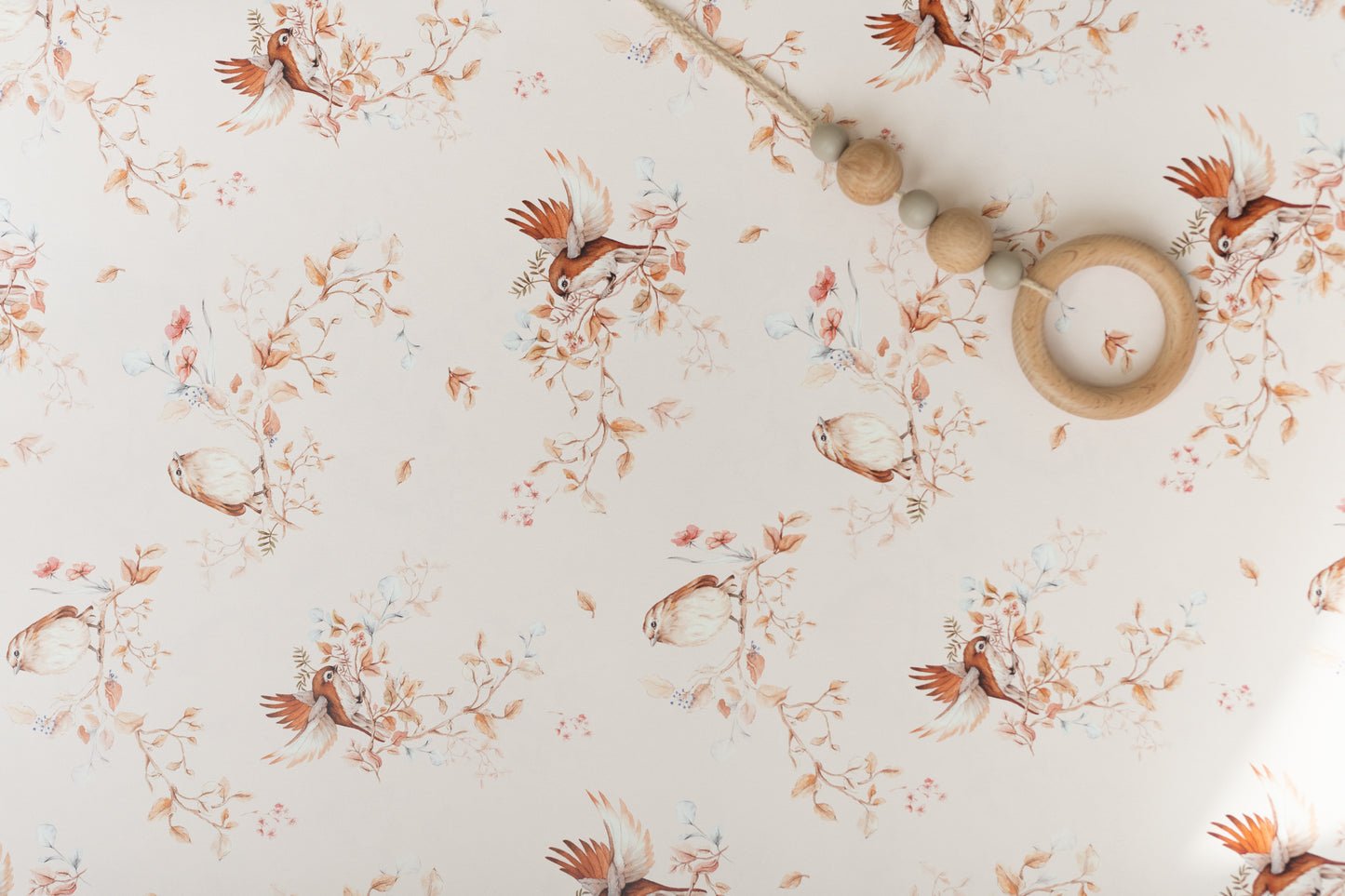 Close-up of Matuu’s ‘Brunch on Branches’ wallpaper – small pattern size, featuring delicate birds on light grey branches with a soft cream and pink background.