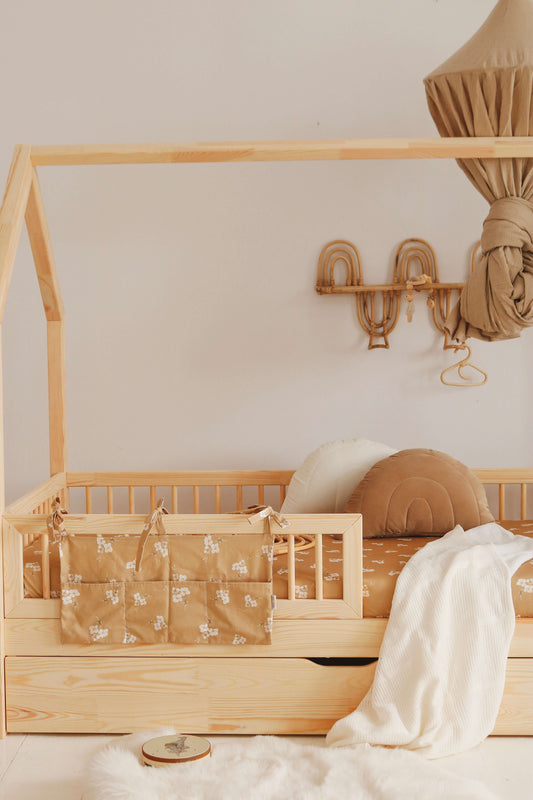Matuu “Caramel Small Flowers” bed pocket on a wooden crib – cozy and functional nursery storage in earthy, natural tones.