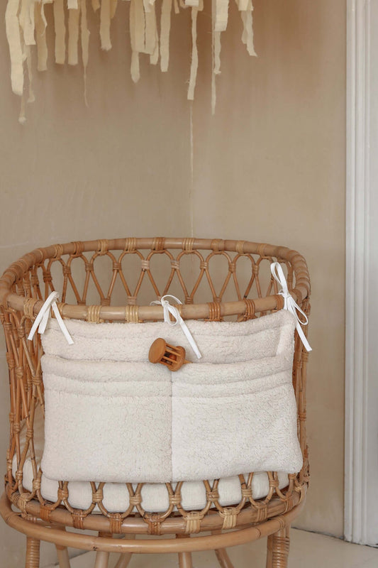 Front view of Matuu quilted crib organizer – soft white muslin with two spacious pockets.