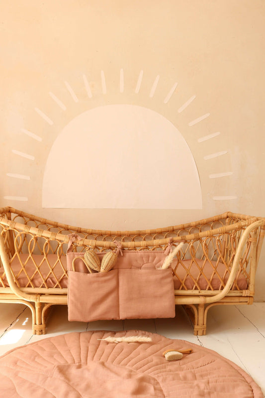 Vintage-inspired nursery with retro pink bed pocket and matching quilted playmat.