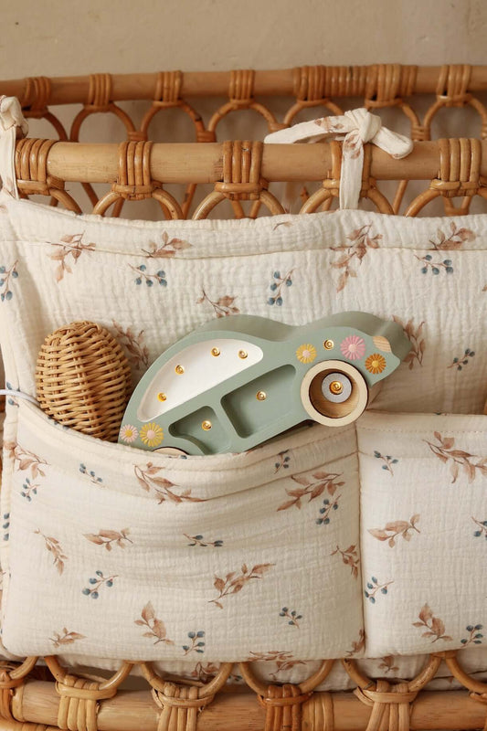 Close-up of Matuu bed pocket – woodland-themed fabric with soft natural tones and ties