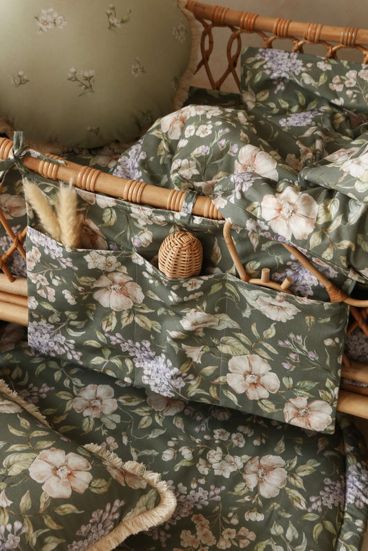 Close-up of the Matuu “May Garden” bed pocket on green background – delicate floral details and soft cotton texture for stylish, everyday nursery storage.